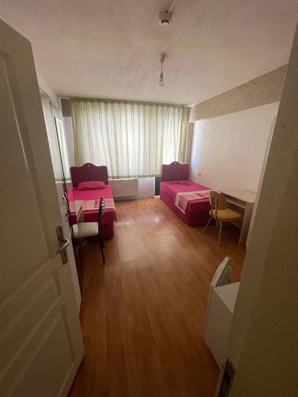 Elit Kız Öğrenci Yurdu'nda iki yatak, çalışma masaları ve dolap bulunan çift kişilik oda